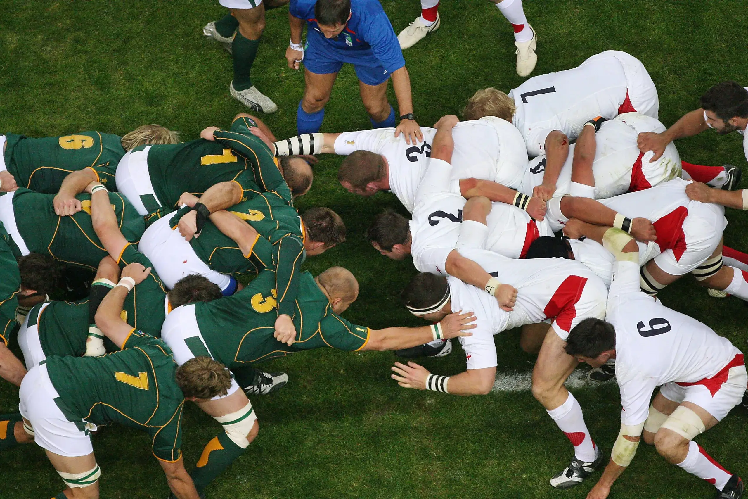A high-angle view of two rugby teams packed together to form a scrum